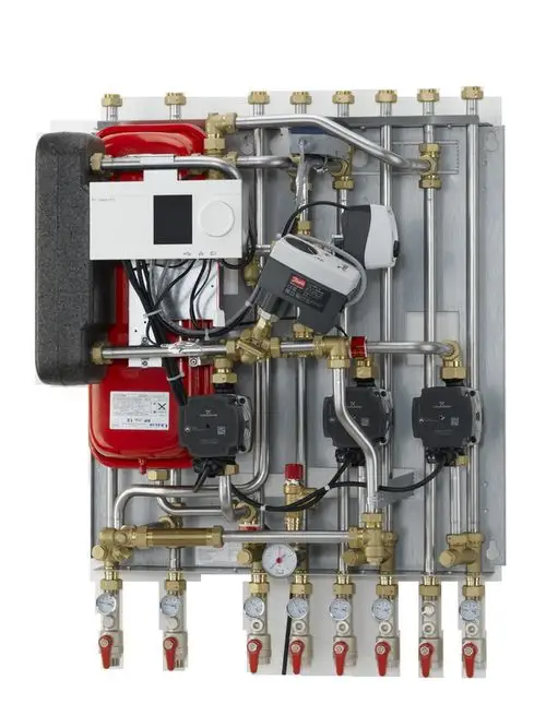 Hausstation mit Rohren, Ventilen und einem Danfoss Steuergerät, zur Regelung von Heiz- und Warmwasserversorgung in einem Gebäude.